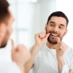 Persona cuidando su salud bucal para evitar riesgos con el biofilm - Clínica dental en Oviedo