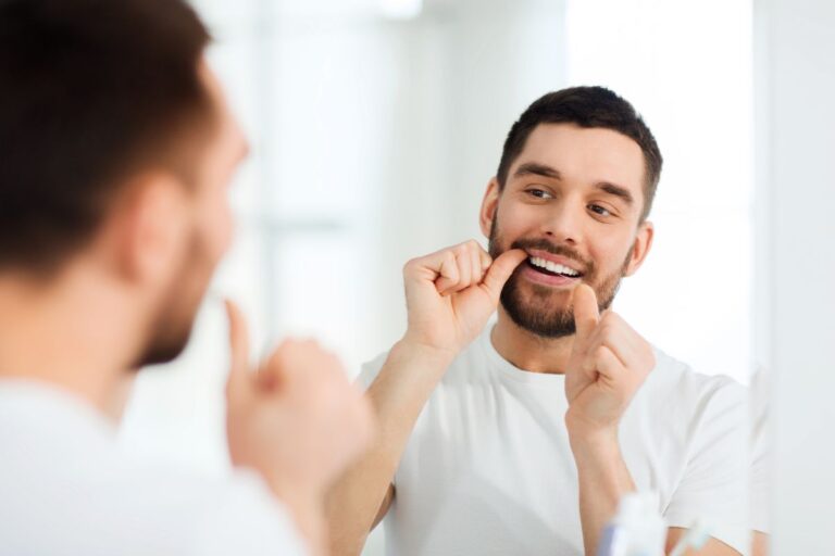 Persona cuidando su salud bucal para evitar riesgos con el biofilm - Clínica dental en Oviedo